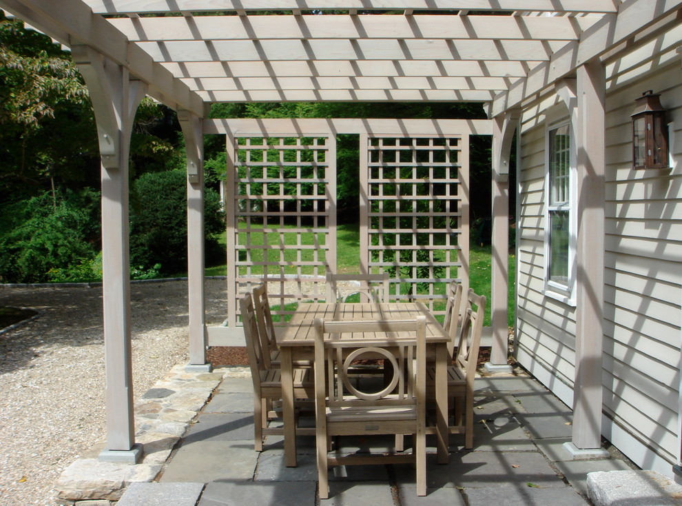 Imagen de patio campestre pequeño en patio delantero con adoquines de piedra natural y pérgola