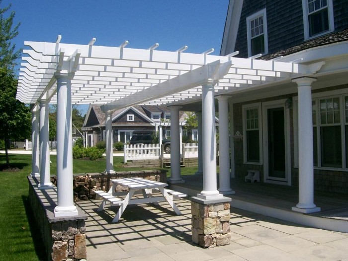 Modelo de patio de estilo americano en patio lateral con adoquines de hormigón y pérgola