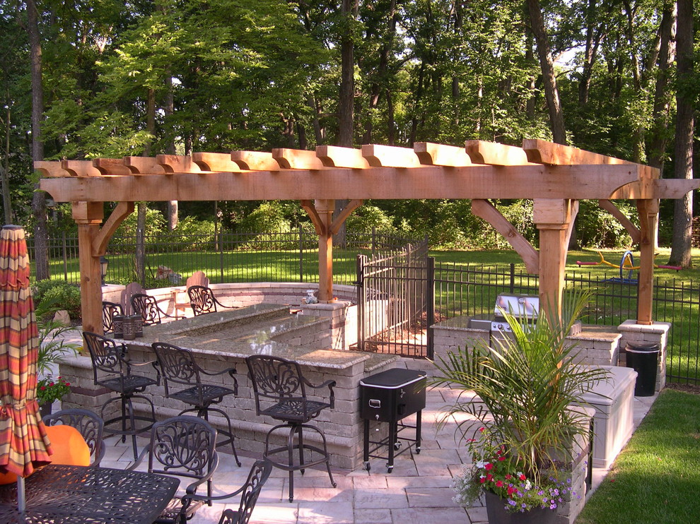 Aménagement d'une terrasse arrière classique de taille moyenne avec une cuisine d'été, du carrelage et une pergola.