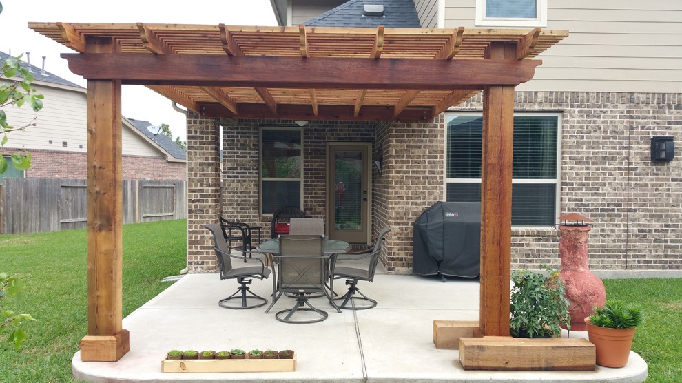 Medium sized traditional back patio in Houston with concrete slabs and a pergola.