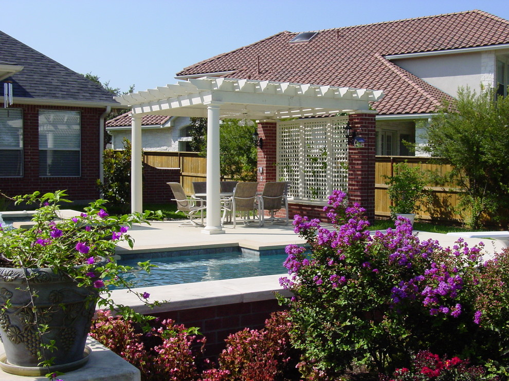Example of a large classic backyard concrete patio fountain design in Austin with a pergola