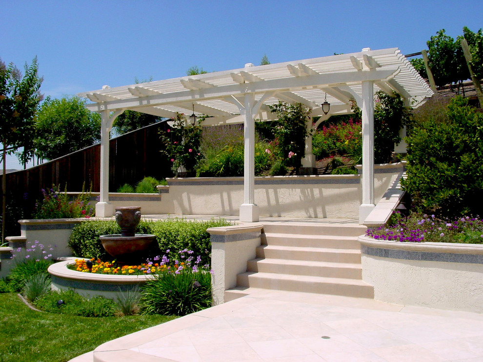 This is an example of a small contemporary back patio in San Francisco with a water feature, concrete slabs and a pergola.