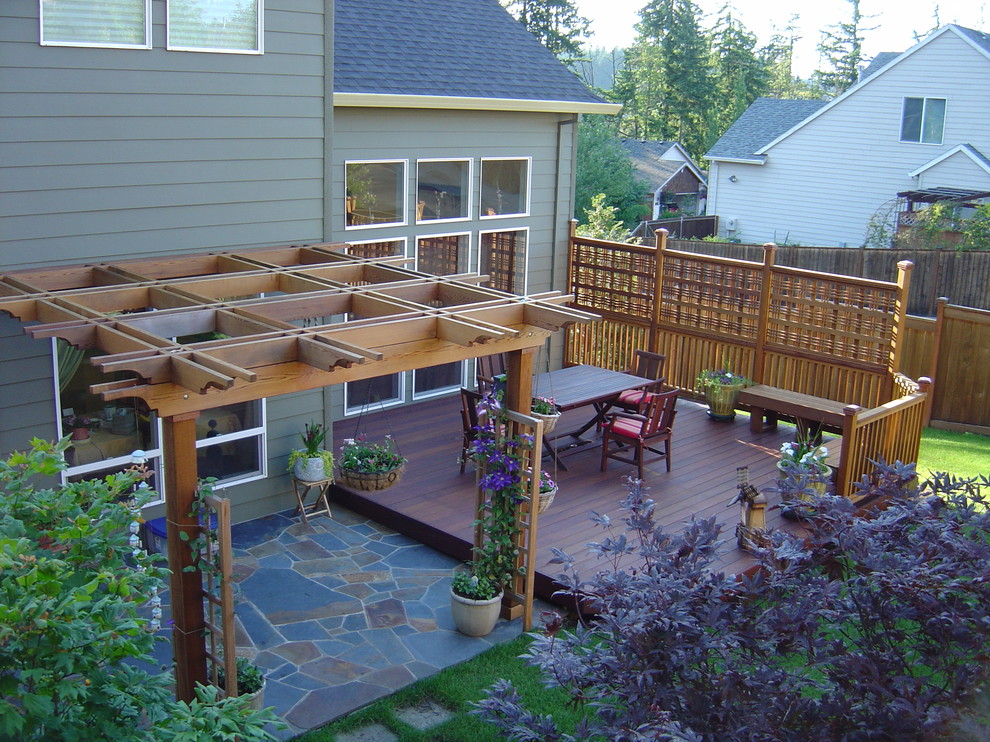 Idee per un patio o portico tradizionale di medie dimensioni e dietro casa con pedane e una pergola
