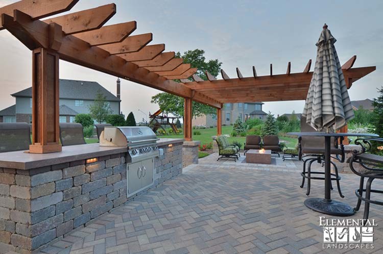 Diseño de patio clásico de tamaño medio en patio trasero con cocina exterior, adoquines de hormigón y pérgola