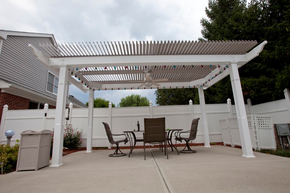 Idee per un patio o portico chic di medie dimensioni e dietro casa con lastre di cemento e una pergola