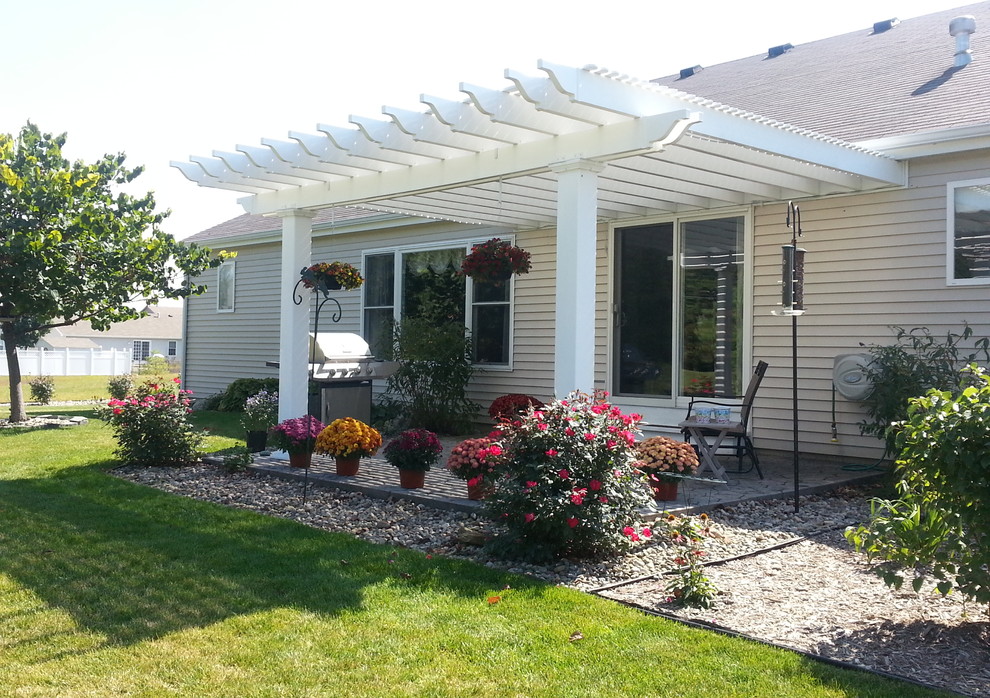 This is an example of a medium sized back patio in Other with concrete paving and a pergola.