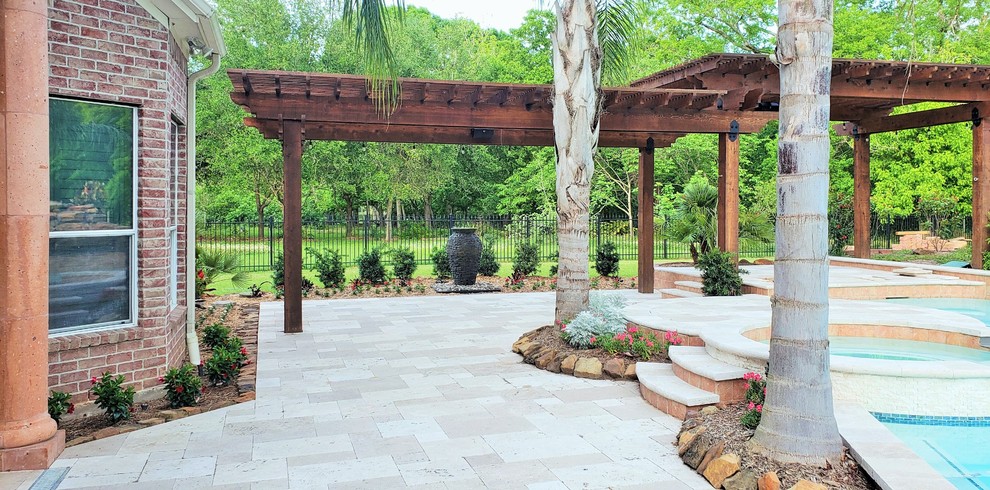 This is an example of an expansive contemporary back patio in Houston with a water feature and a pergola.