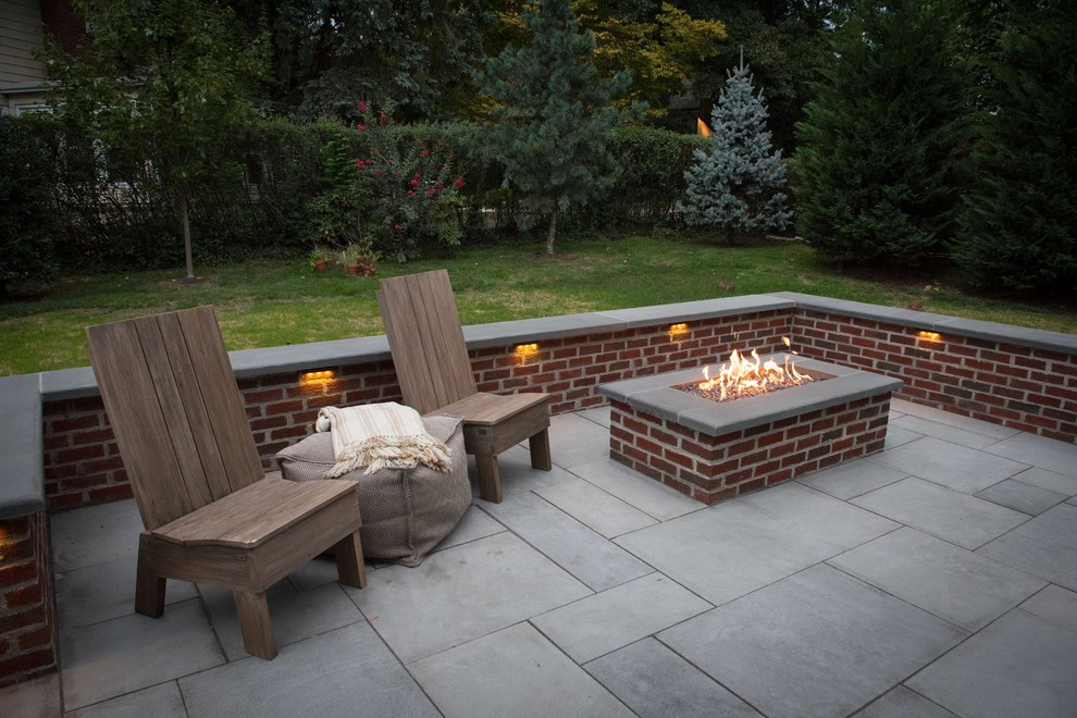 Small classic back patio in New York with a fire feature and natural stone paving.
