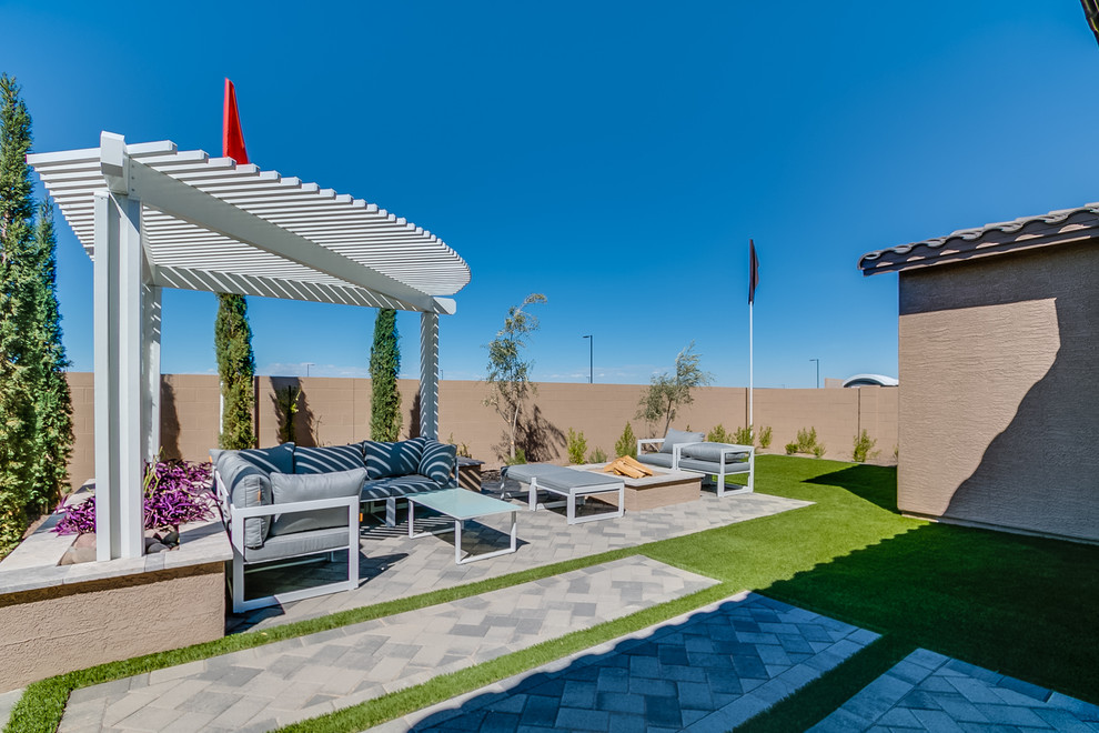 Idées déco pour une grande terrasse arrière contemporaine avec un foyer extérieur, des pavés en brique et une pergola.