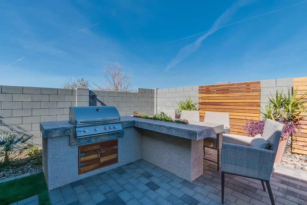 Exemple d'une très grande terrasse arrière tendance avec une cuisine d'été, des pavés en brique et une extension de toiture.