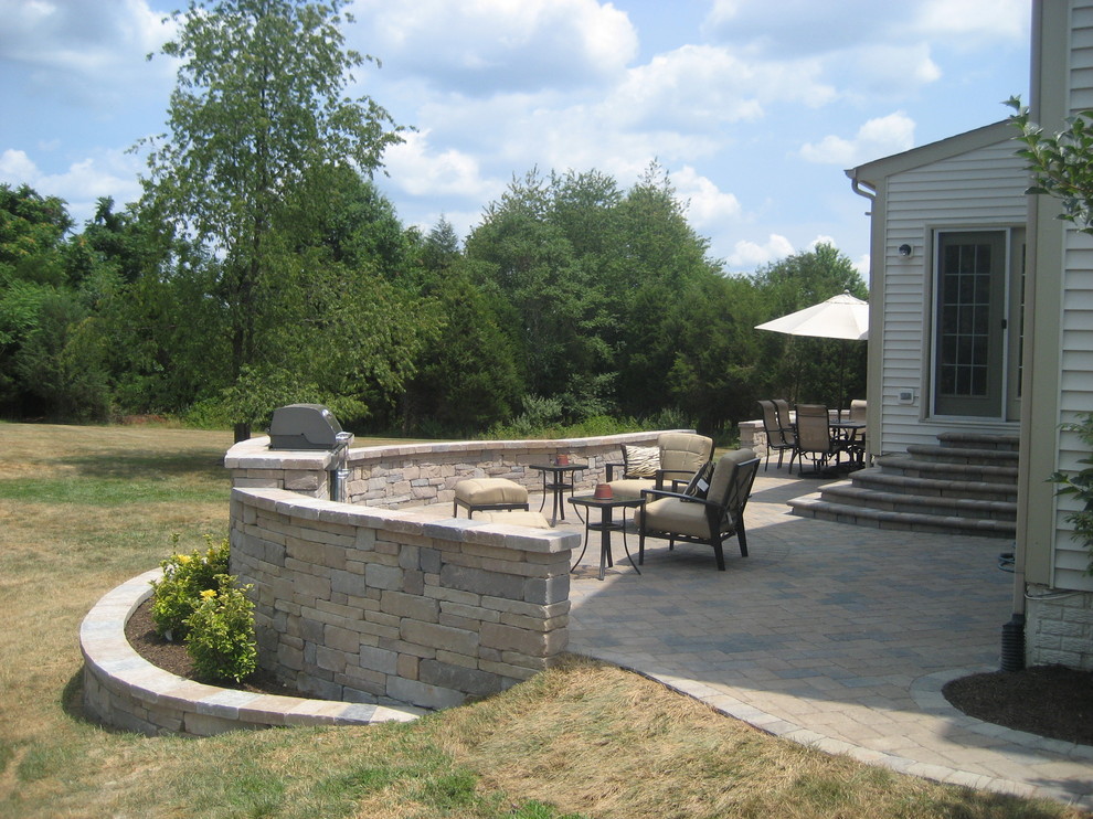 Ejemplo de patio clásico grande sin cubierta en patio trasero con cocina exterior y adoquines de ladrillo