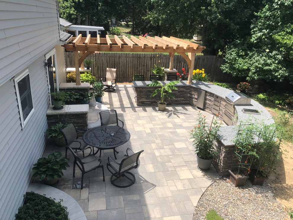 Foto de patio ecléctico extra grande en patio trasero con cocina exterior, adoquines de ladrillo y pérgola