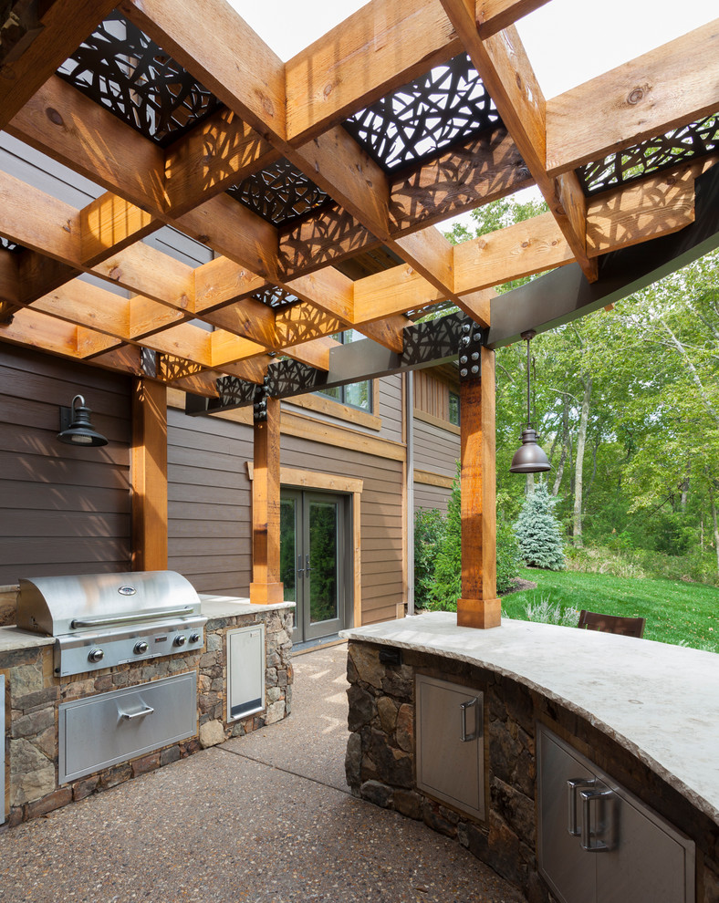 Patio kitchen - large craftsman backyard concrete patio kitchen idea in Kansas City with a pergola