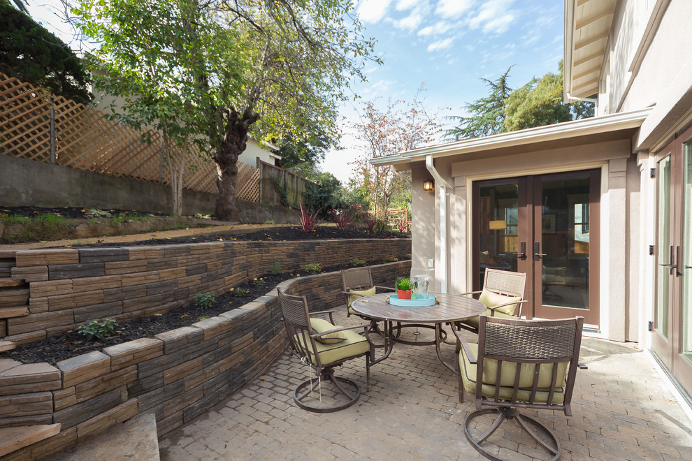 Medium sized contemporary side patio in Other with a potted garden, brick paving and no cover.
