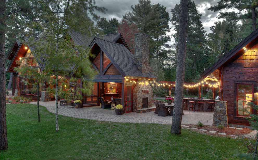 Immagine di un patio o portico rustico dietro casa con un focolare