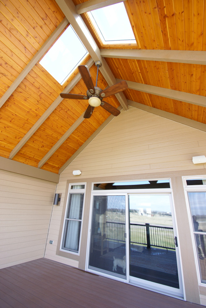 Réalisation d'une terrasse en bois arrière craftsman de taille moyenne avec une extension de toiture.