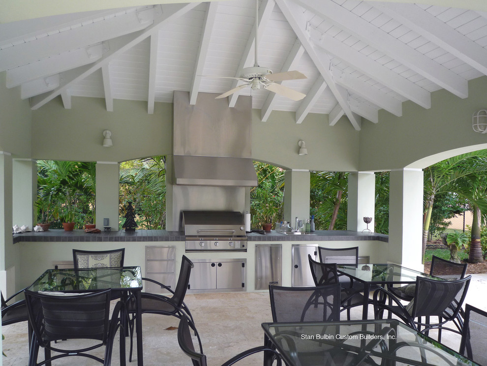 Design ideas for a large world-inspired back patio in Miami with an outdoor kitchen, tiled flooring and a pergola.