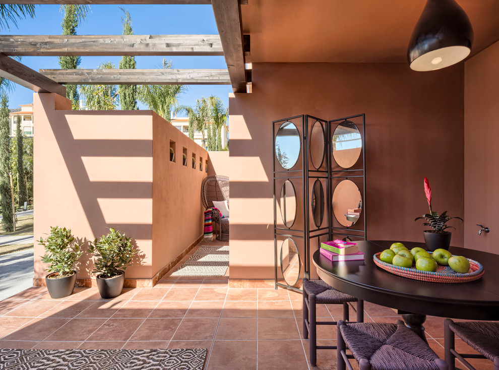 Foto di un patio o portico american style di medie dimensioni e davanti casa con un giardino in vaso, un tetto a sbalzo e piastrelle