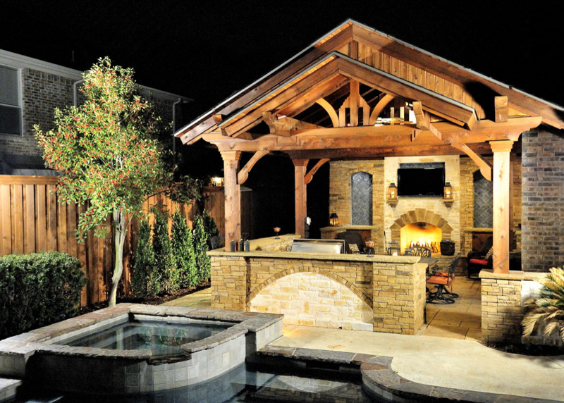 Foto di un patio o portico stile americano di medie dimensioni e dietro casa con un focolare, pavimentazioni in pietra naturale e un gazebo o capanno