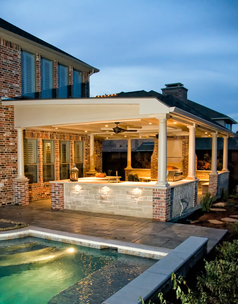 Inspiration for a mid-sized timeless backyard stamped concrete patio remodel in Dallas with a fire pit and a roof extension
