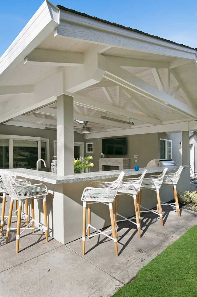 Esempio di un patio o portico classico di medie dimensioni e dietro casa con cemento stampato e un tetto a sbalzo
