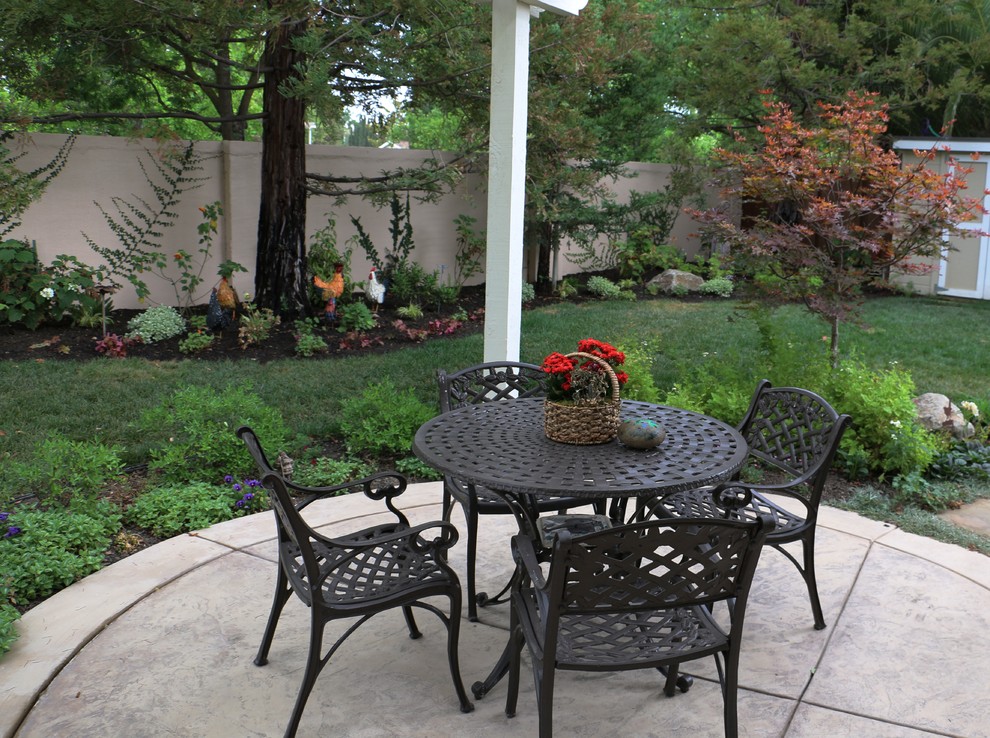 Cette image montre une grande terrasse arrière traditionnelle avec une cuisine d'été, du béton estampé et une pergola.