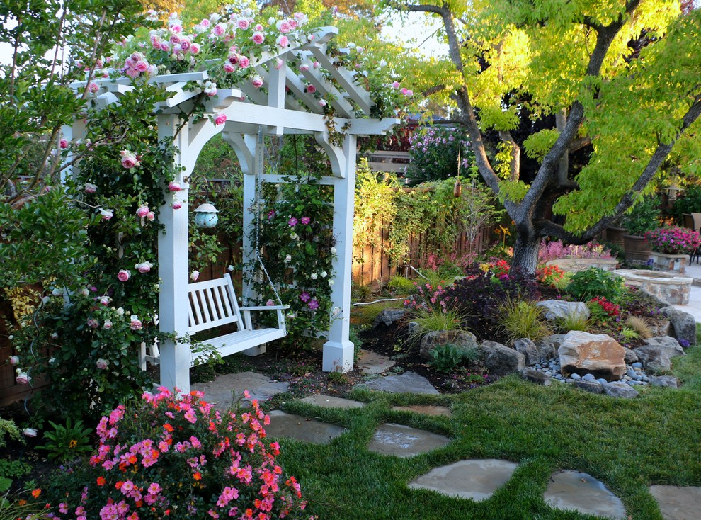 Idée de décoration pour une grande terrasse arrière tradition avec un foyer extérieur et des pavés en pierre naturelle.