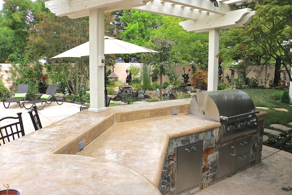 Inspiration for a large timeless backyard stamped concrete patio kitchen remodel in San Francisco with a pergola