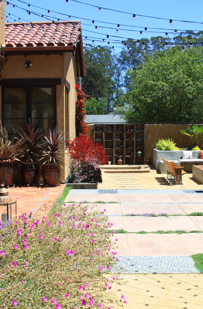 Photo of a large mediterranean back patio in San Francisco with no cover, a fire feature and natural stone paving.