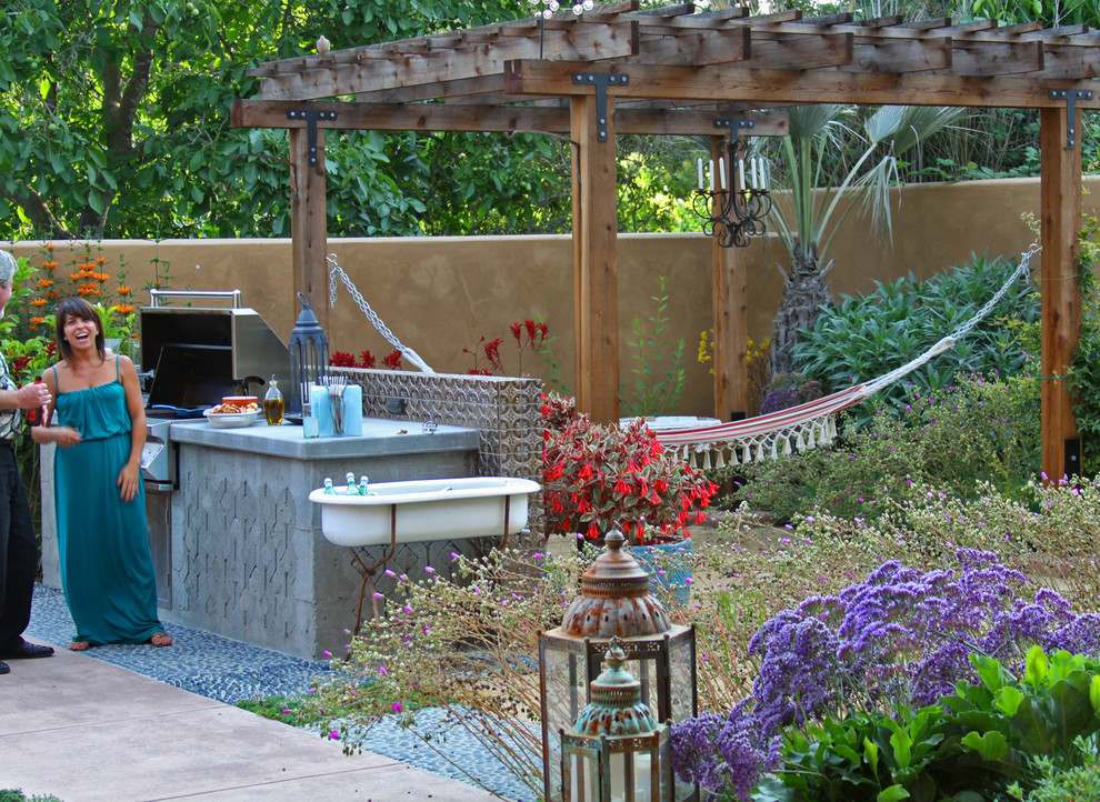Idee per un grande patio o portico mediterraneo dietro casa con una pergola e cemento stampato