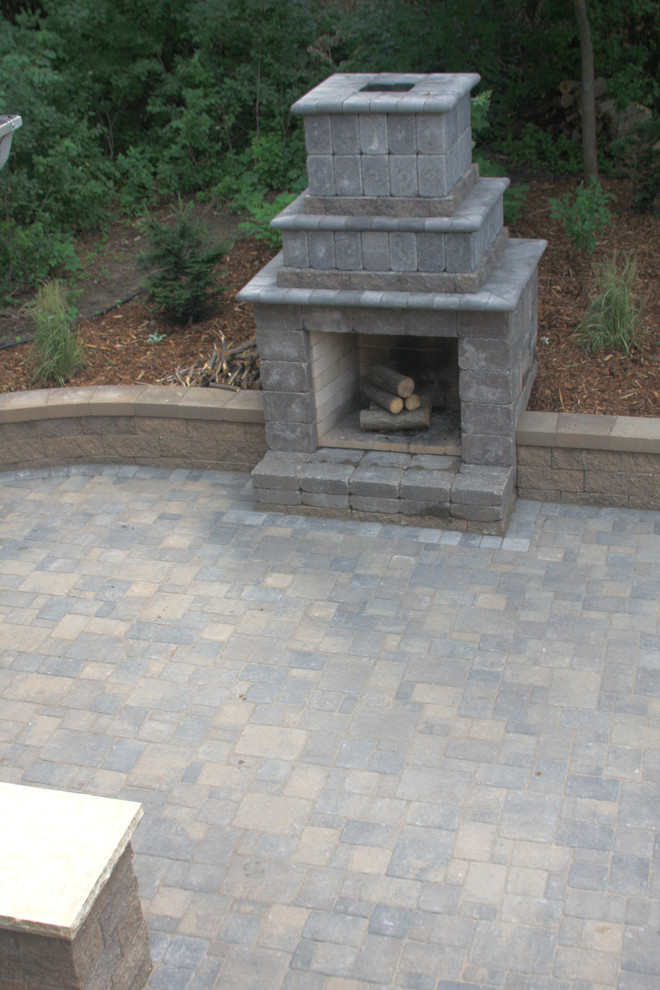 Design ideas for a medium sized traditional back patio in Minneapolis with a fire feature, concrete paving and no cover.