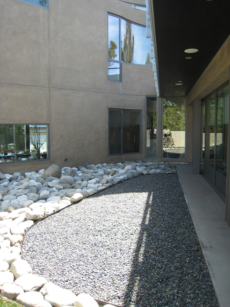 На фото: двор среднего размера на внутреннем дворе в стиле модернизм с покрытием из гравия без защиты от солнца
