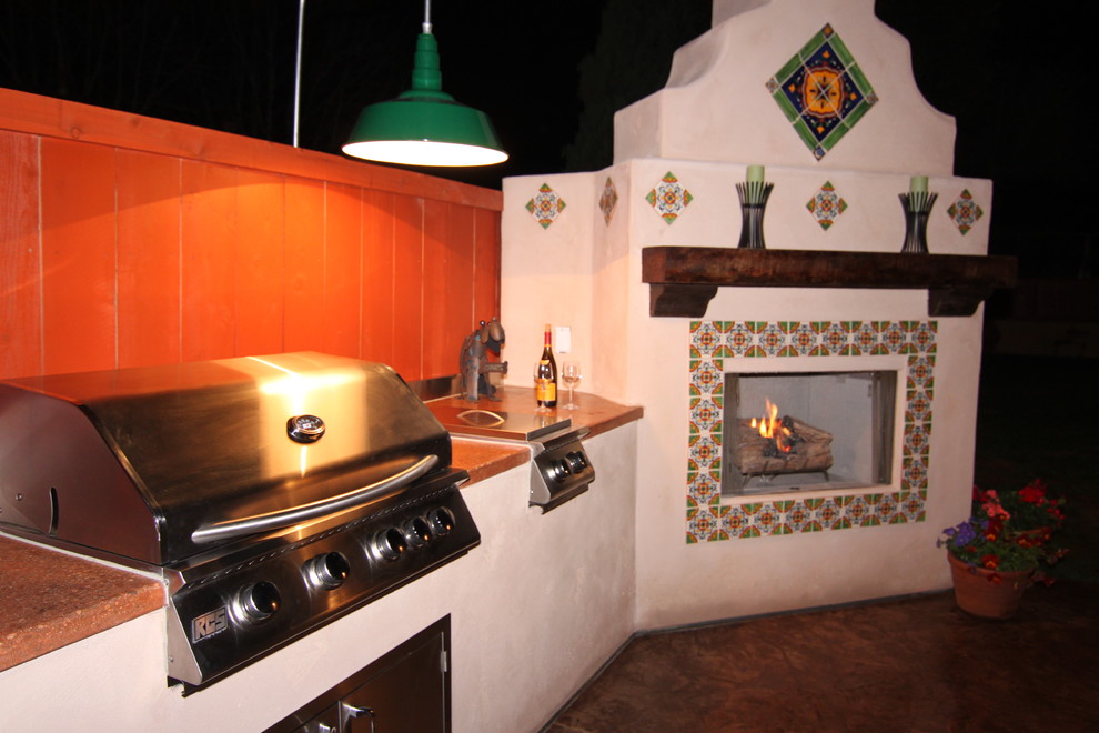 Photo of a medium sized mediterranean side patio in San Diego with an outdoor kitchen, stamped concrete and no cover.