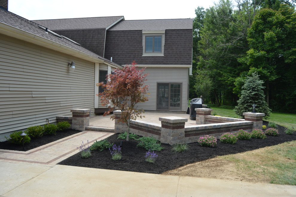 Medium sized traditional front patio in Other with brick paving.
