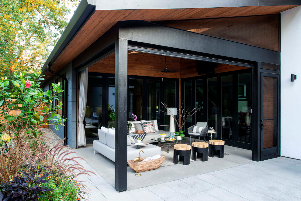 Ispirazione per un piccolo patio o portico minimal con lastre di cemento e un tetto a sbalzo
