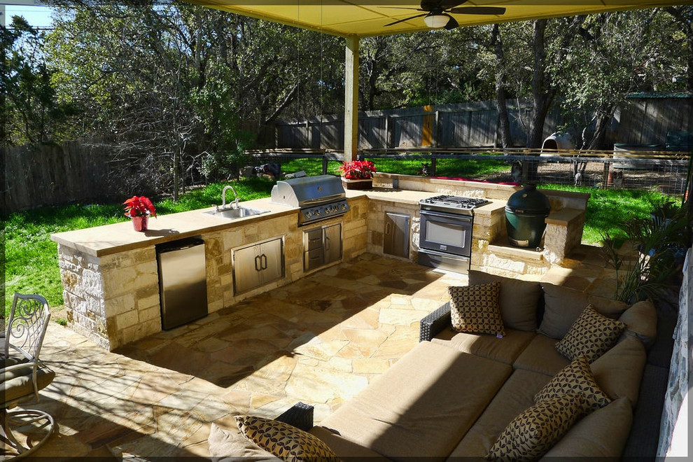 Aménagement d'une terrasse arrière classique de taille moyenne avec une cuisine d'été, des pavés en pierre naturelle et une extension de toiture.