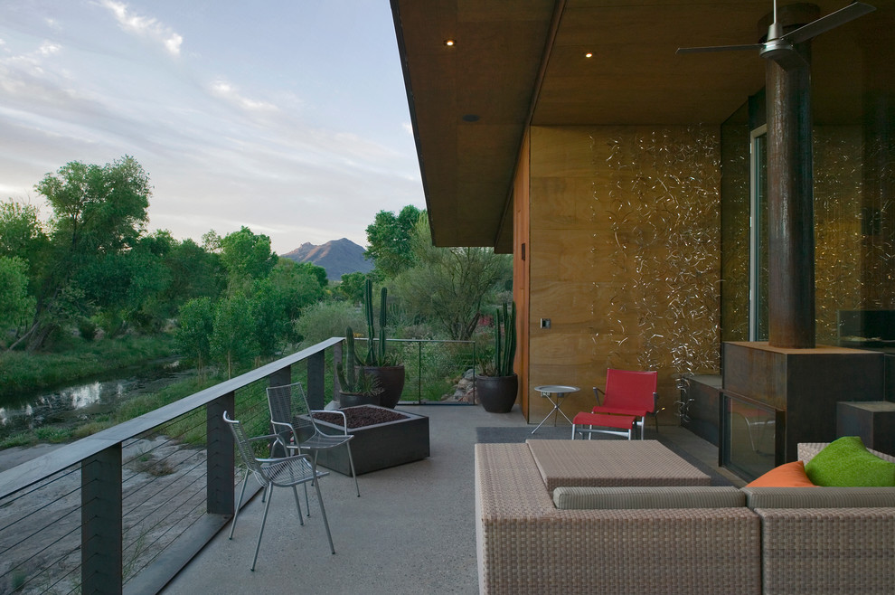 Inspiration pour une terrasse minimaliste avec un foyer extérieur.