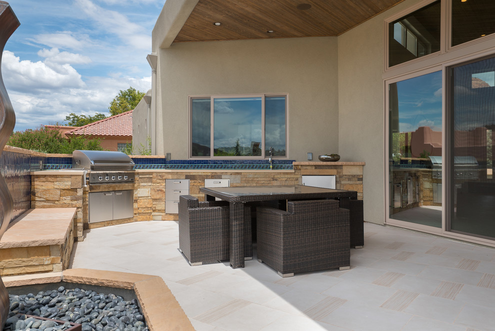 Immagine di un grande patio o portico minimal dietro casa con un tetto a sbalzo e piastrelle