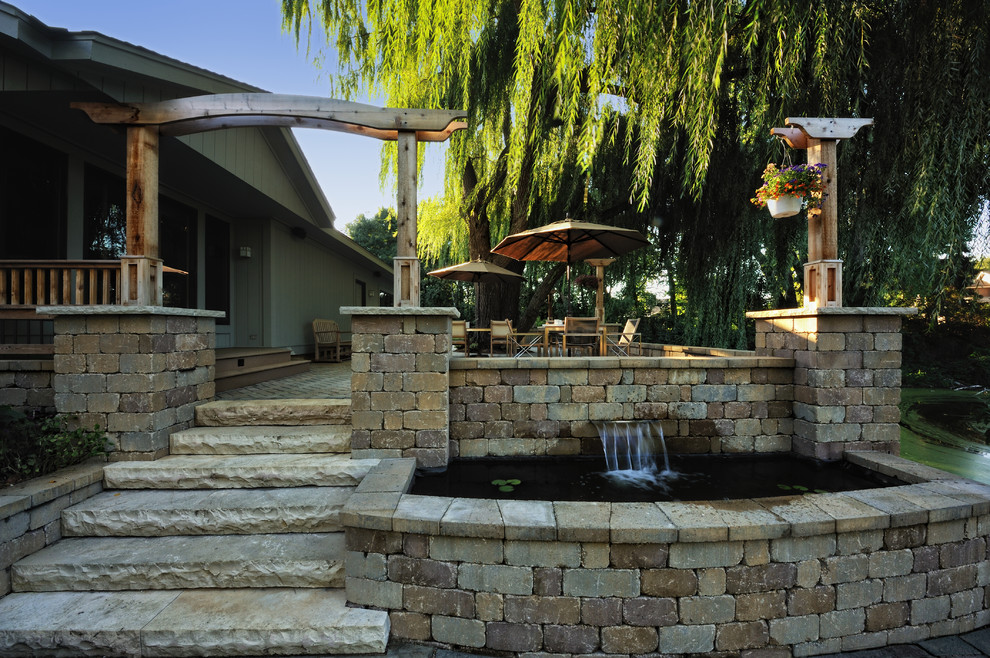 Esempio di un ampio patio o portico minimal dietro casa con fontane e pavimentazioni in pietra naturale