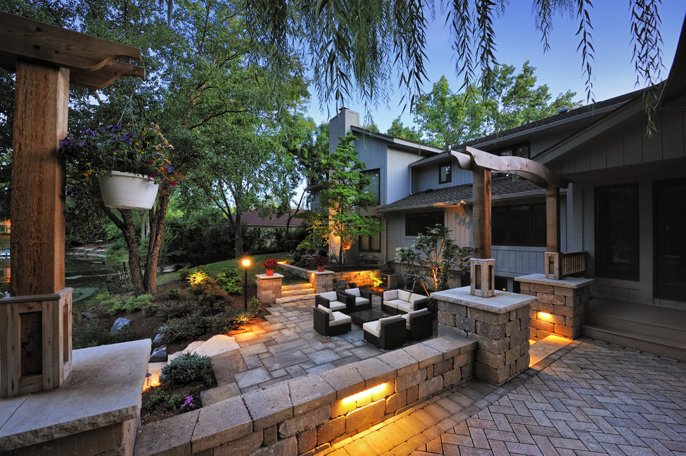 Réalisation d'une très grande terrasse arrière design avec des pavés en béton et aucune couverture.