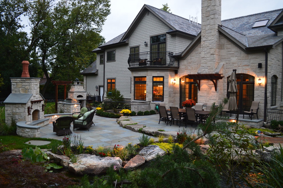 Foto di un grande patio o portico rustico dietro casa con pavimentazioni in pietra naturale e nessuna copertura