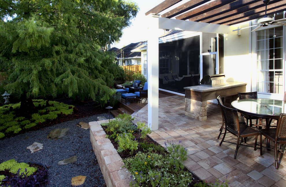 Aménagement d'une terrasse arrière exotique de taille moyenne avec une cuisine d'été, des pavés en béton et une pergola.