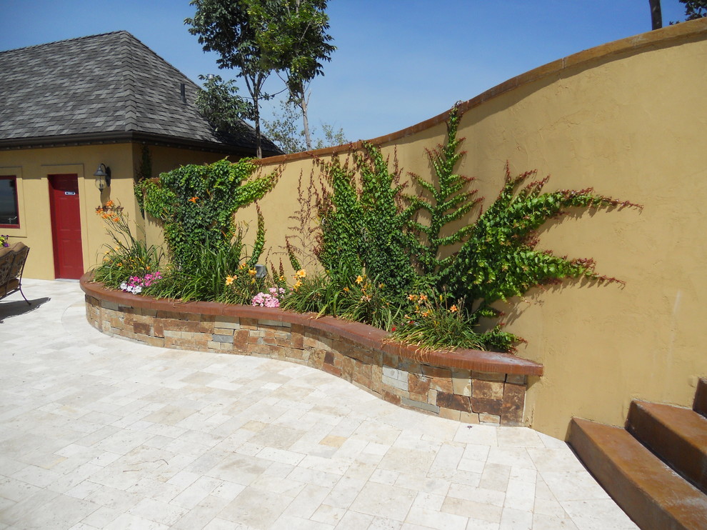 Esempio di un patio o portico tropicale con un giardino in vaso e cemento stampato