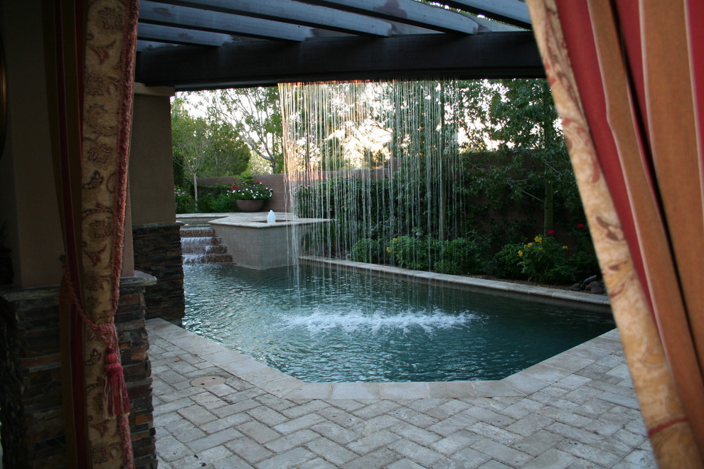 Large tuscan backyard stone patio fountain photo in Las Vegas with a pergola