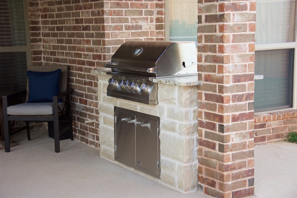 Example of a large mountain style backyard concrete patio kitchen design in Austin with a pergola