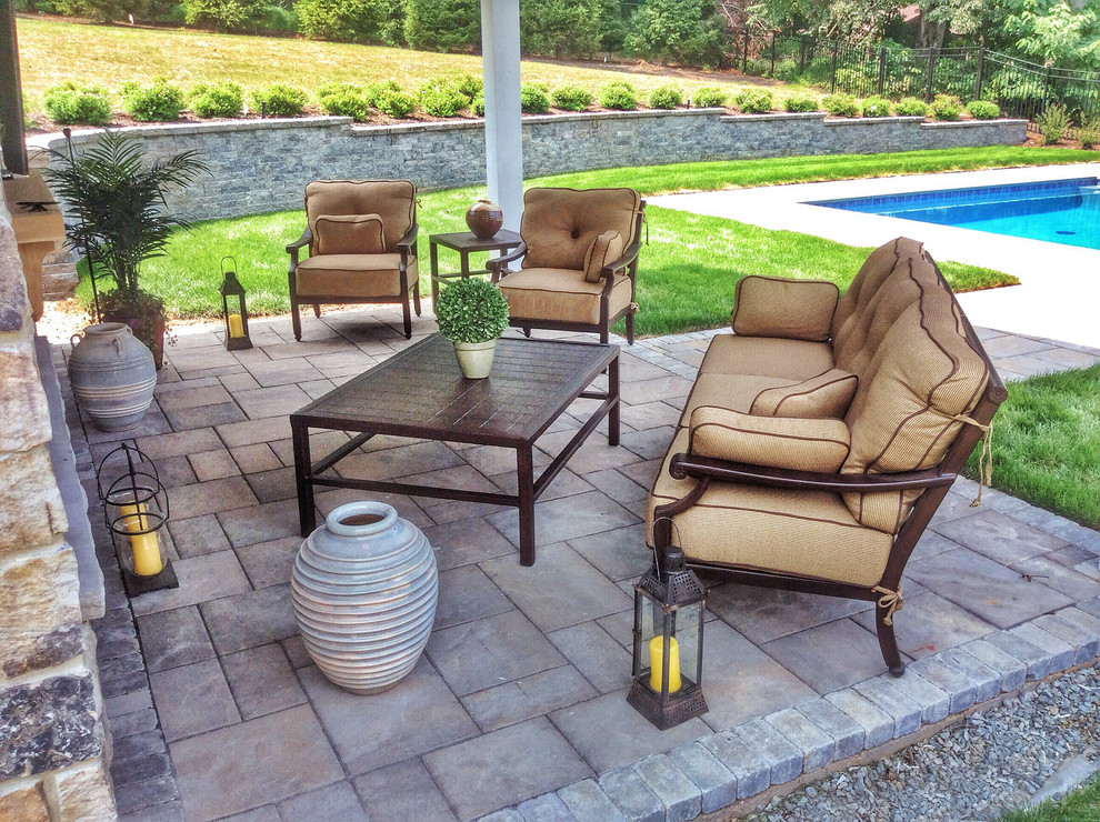 This is an example of a large classic back patio in New York with concrete paving, a gazebo and a fire feature.