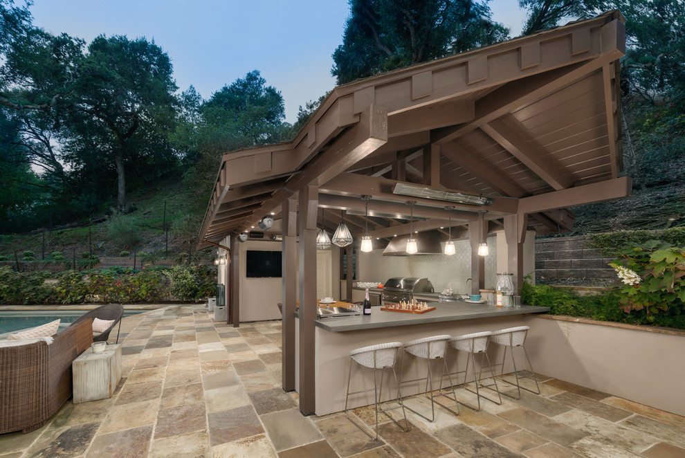Foto de patio actual de tamaño medio en patio lateral con cocina exterior, adoquines de piedra natural y cenador