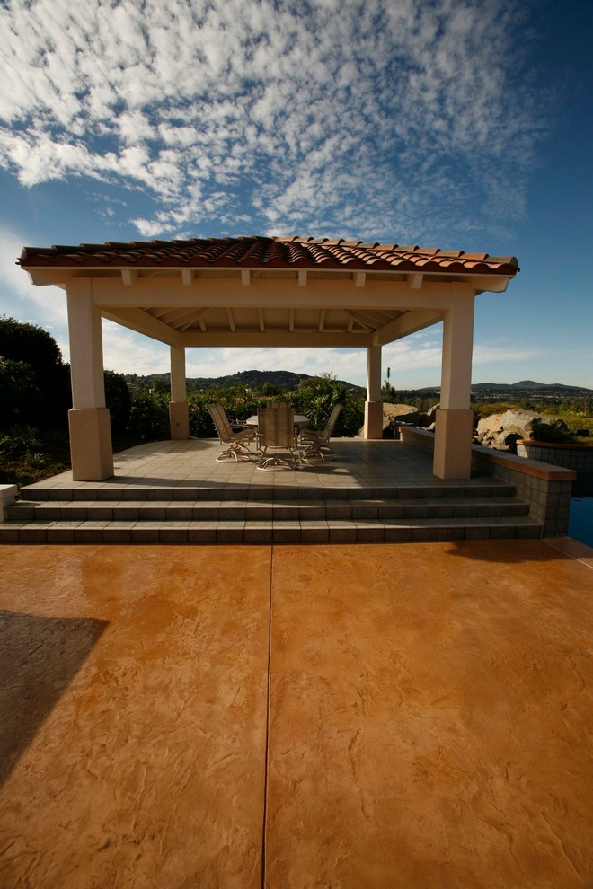 Cette image montre une terrasse arrière traditionnelle de taille moyenne avec une dalle de béton et un gazebo ou pavillon.