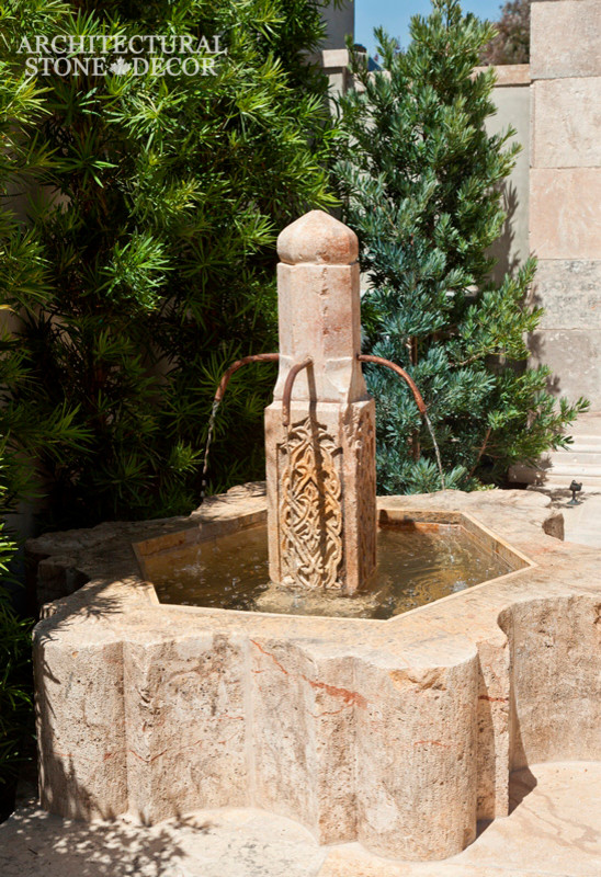 На фото: двор среднего размера на заднем дворе в средиземноморском стиле с фонтаном и покрытием из каменной брусчатки без защиты от солнца с