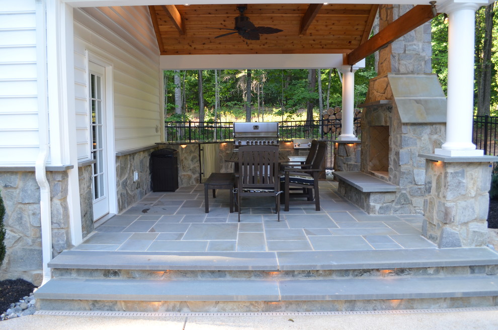 Idee per un patio o portico classico di medie dimensioni e dietro casa con pavimentazioni in pietra naturale e un tetto a sbalzo